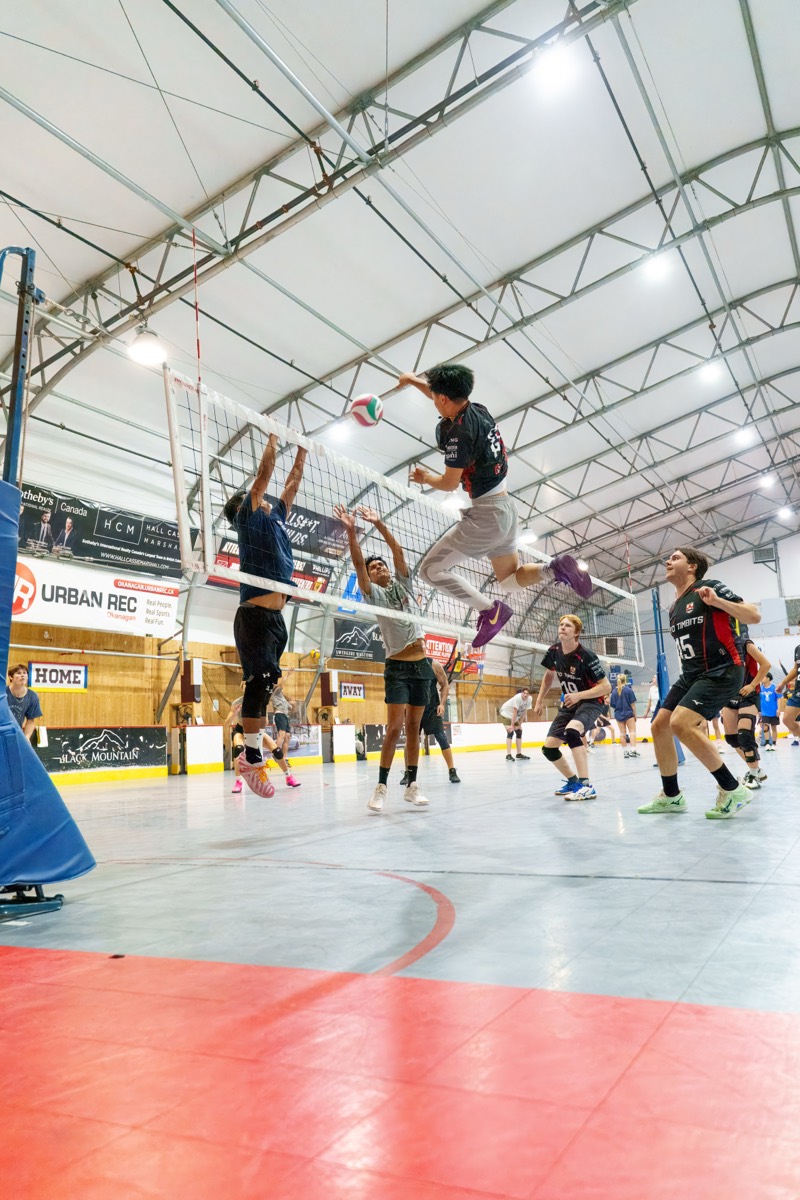 Player leaping high above the net for a spike