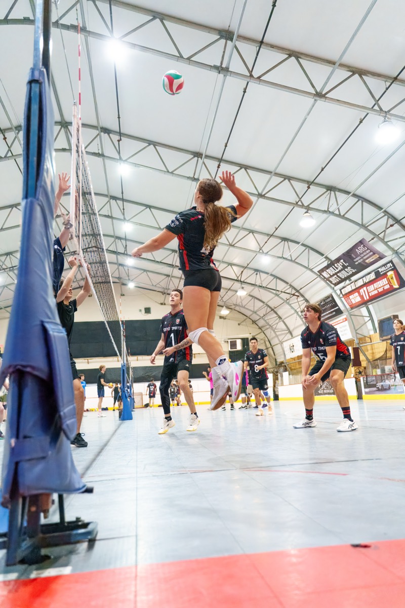 Player rising for a jump serve mid-rally
